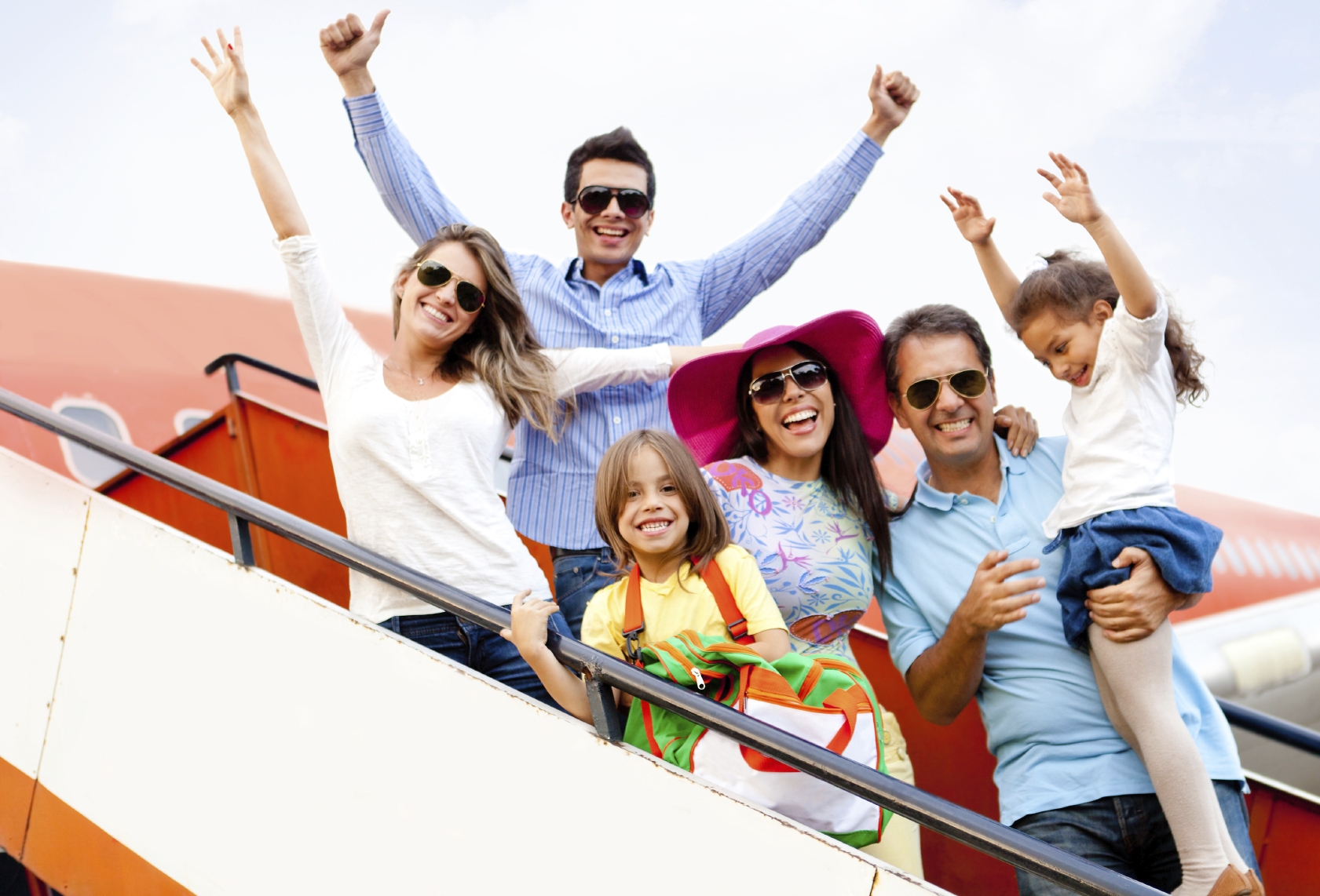 Excited family with arms up traveling by airplane
